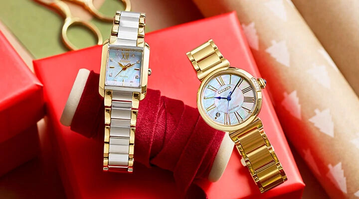 Image featuring two women's watches sitting on top of gift wrapping - Bianca watch model EW5554-58D and Citizen L Mae watch model EM1062-57D